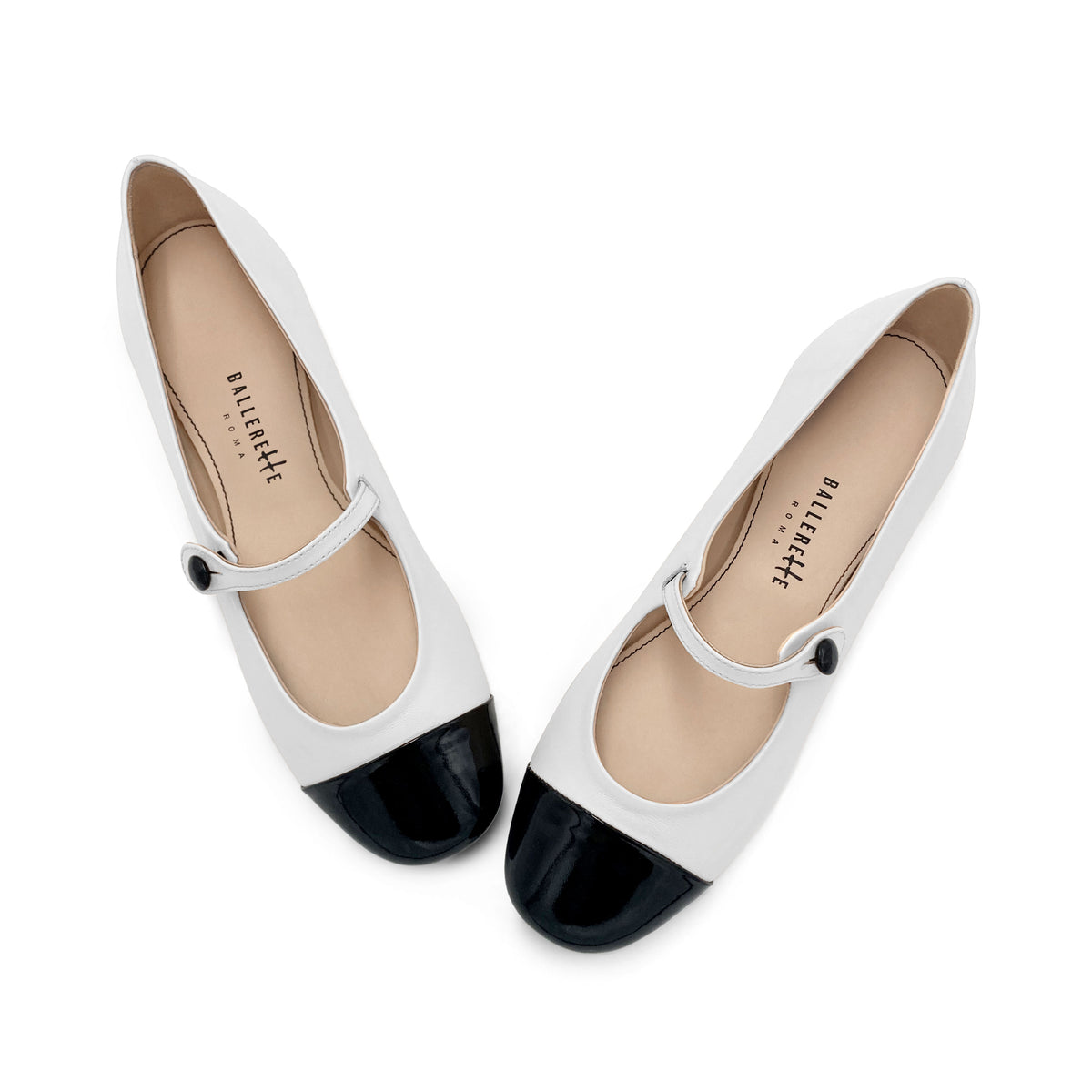 White ballet flats with black patent toe and strap