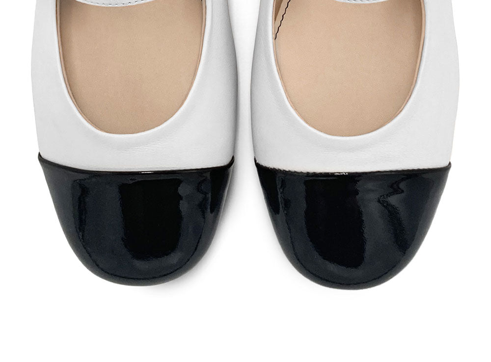 White ballet flats with black patent toe and strap