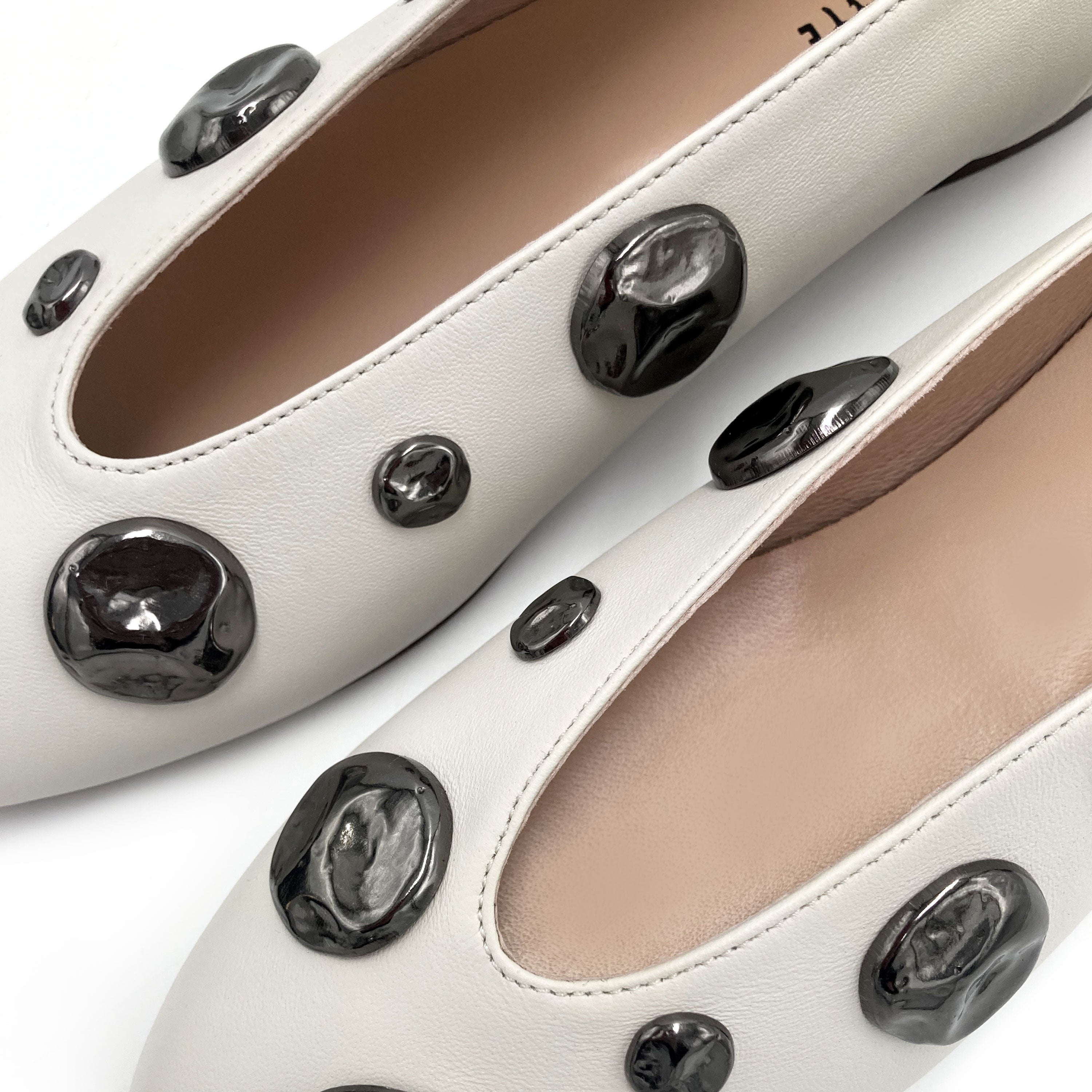 Ivory white leather ballet flats with V-cut and iron studs