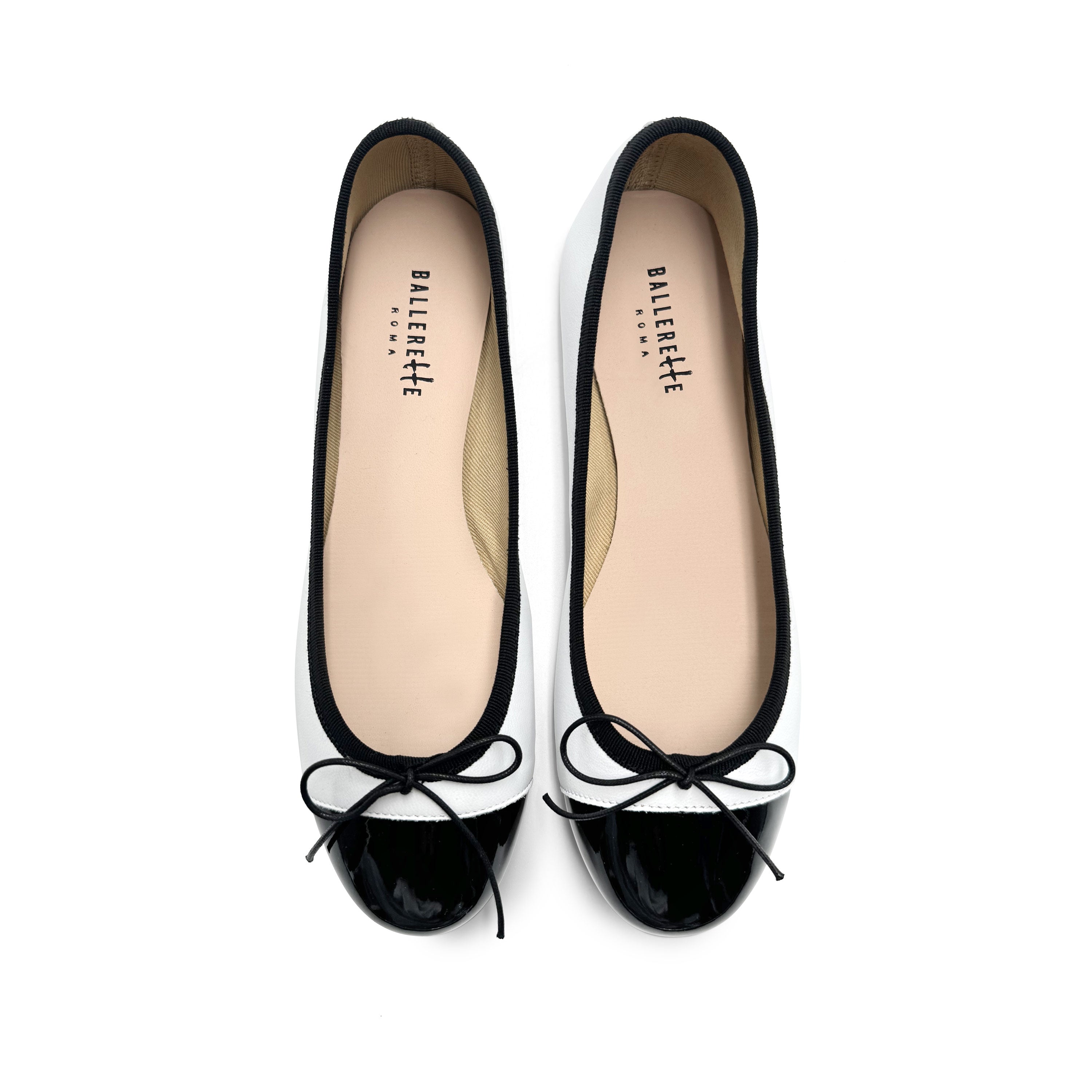 White leather ballet flats with black patent toe