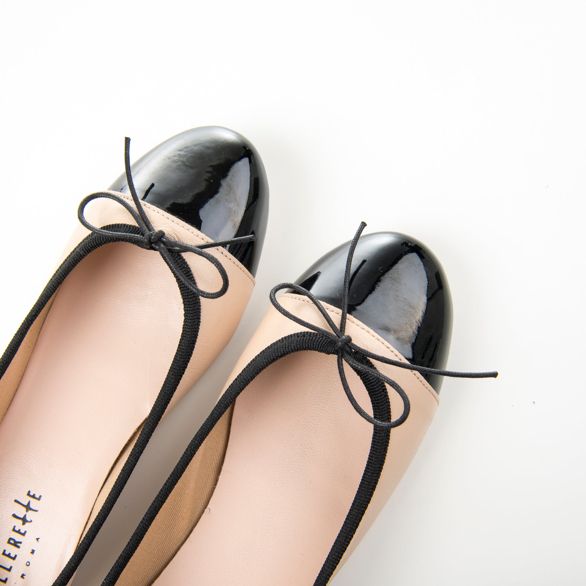 Blush pink leather ballet flats with black patent toe