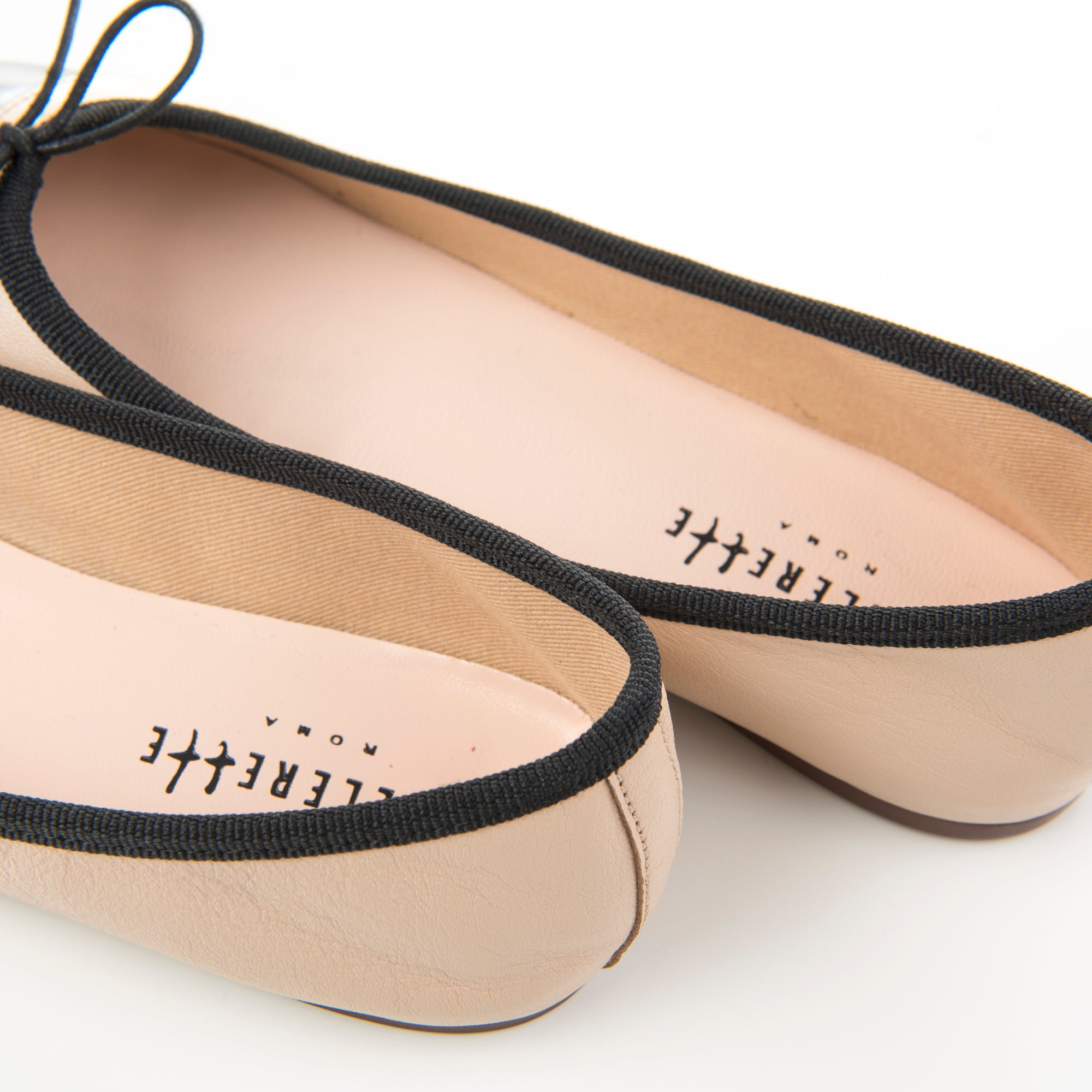 Blush pink leather ballet flats with black patent toe