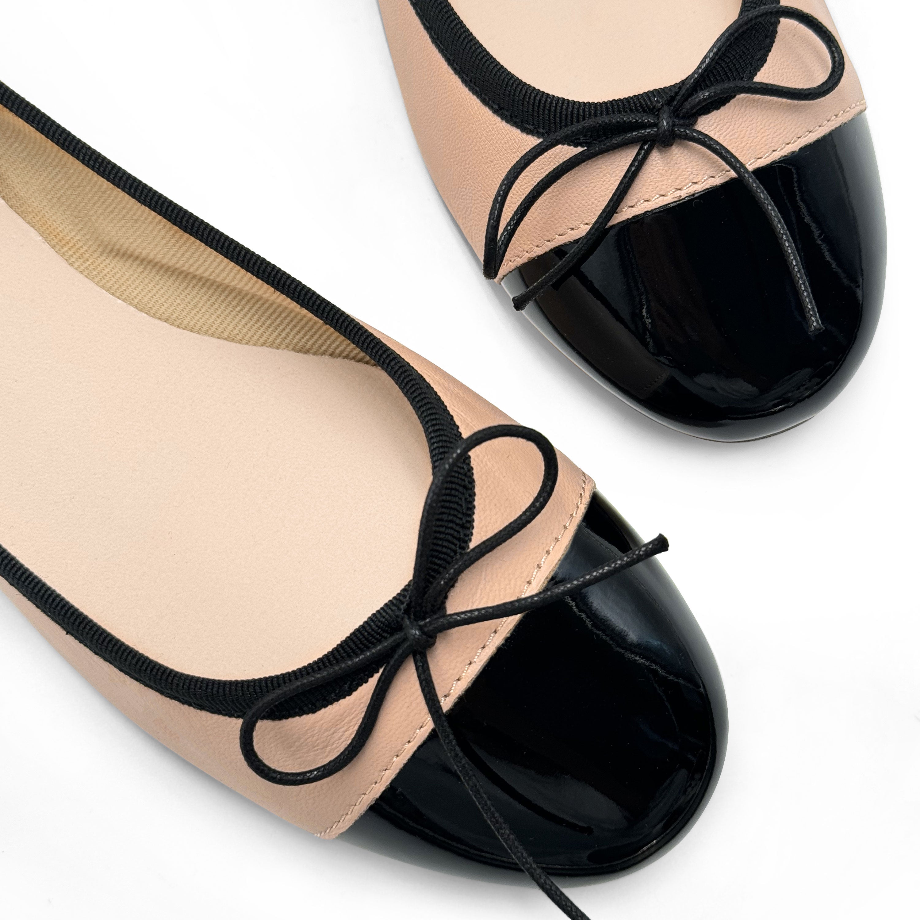 Blush pink leather ballet flats with black patent toe