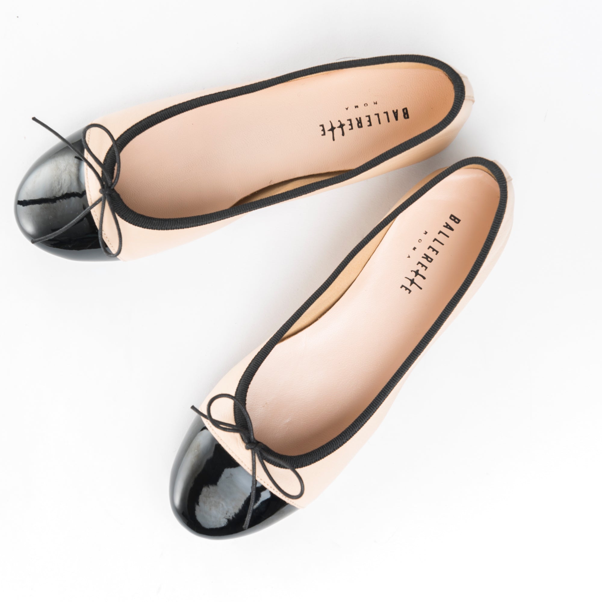 Blush pink leather ballet flats with black patent toe