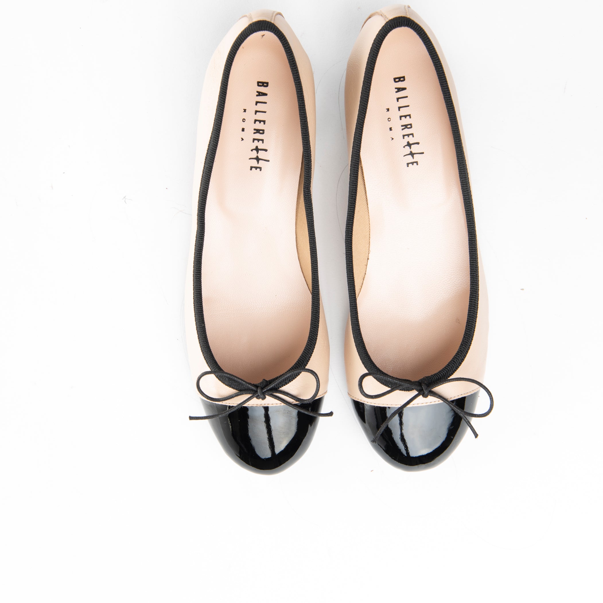 Blush pink leather ballet flats with black patent toe