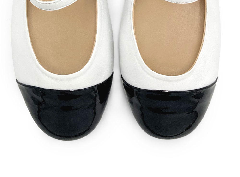White ballet flats with black patent toe and strap